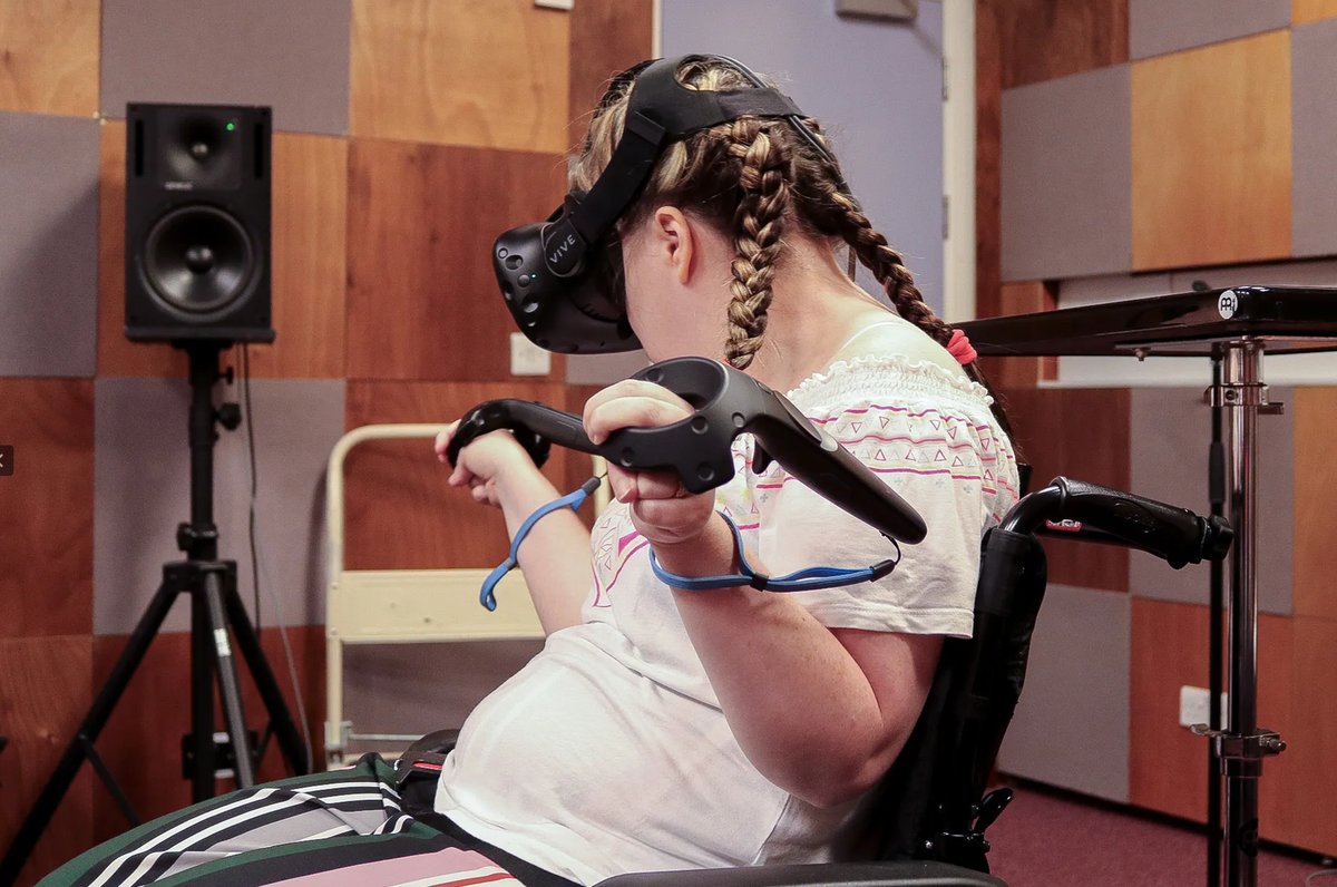 Mary Louise with the HTC Vive headset and controller attached using an atypical grip